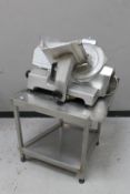 A commercial meat slicer on two-tier preparation table
