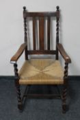 An early twentieth century oak barley twist rush seated armchair