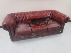 A red buttoned leather Chesterfield three seater settee with footstool
