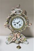 A Meissen four seasons china mantel clock encrusted with flower and cherub decoration with pendulum