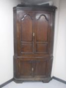 A George III oak double door corner cabinet
