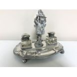 An antique silver plated figural inkstand with two inkwells, depicting St.