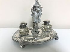 An antique silver plated figural inkstand with two inkwells, depicting St.