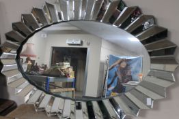 A contemporary all glass sunburst mirror