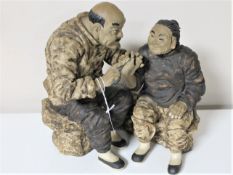 A Chinese pottery figure depicting two figures, signed,