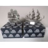 Two boxed metal sailing ships,