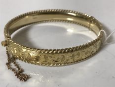 A 9ct gold hinged bangle with engraved decoration CONDITION REPORT: 15.