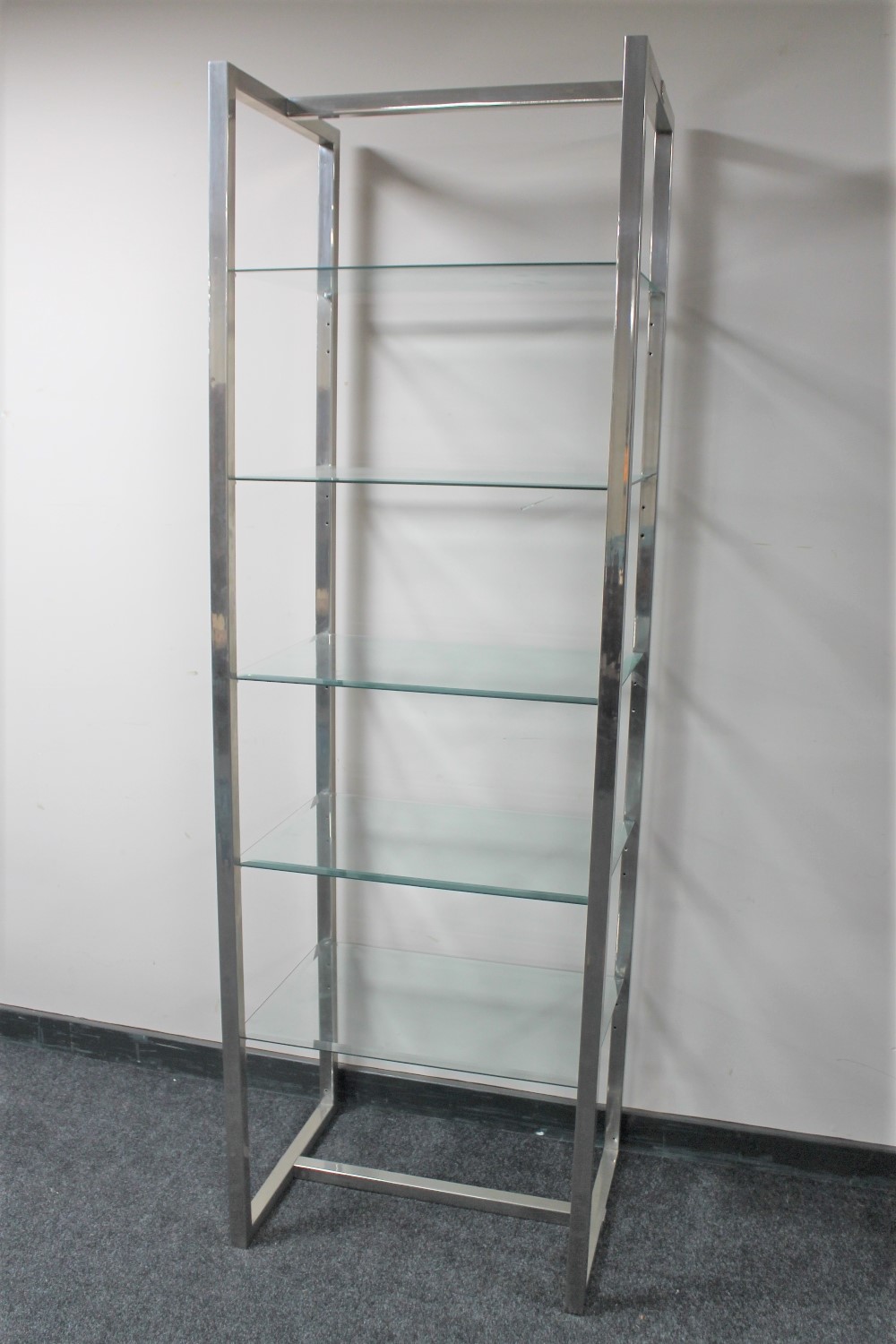 A set of contemporary chrome five tier shelves