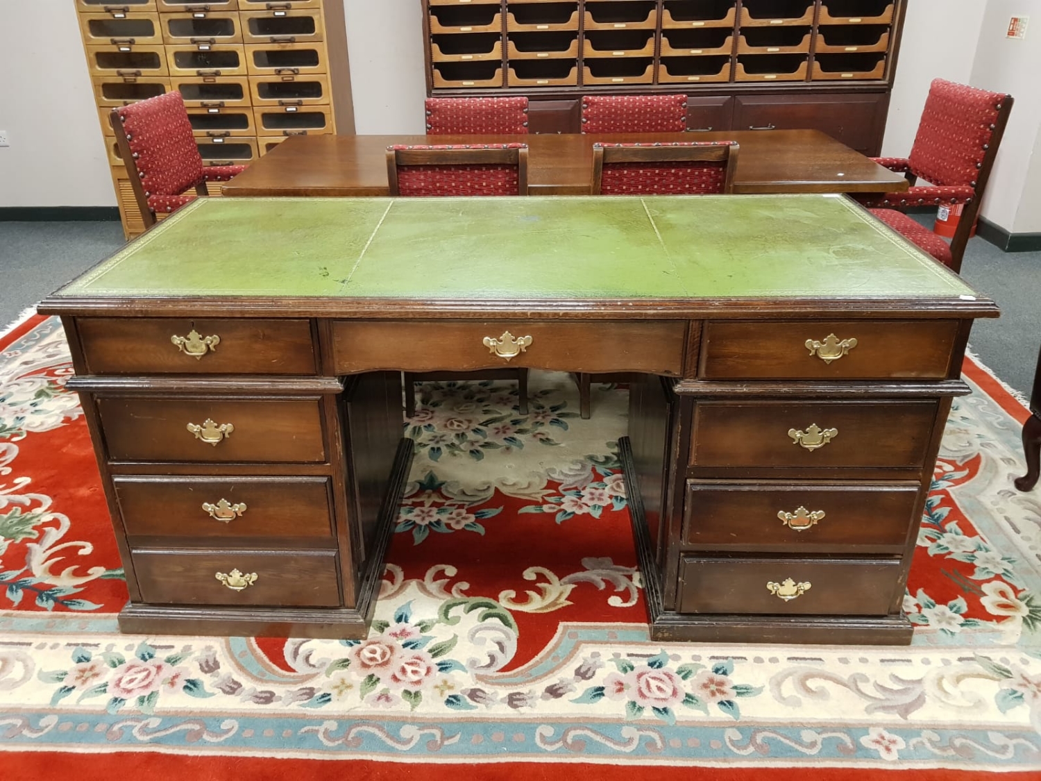 An oak twin pedestal desk with green tooled leather top,