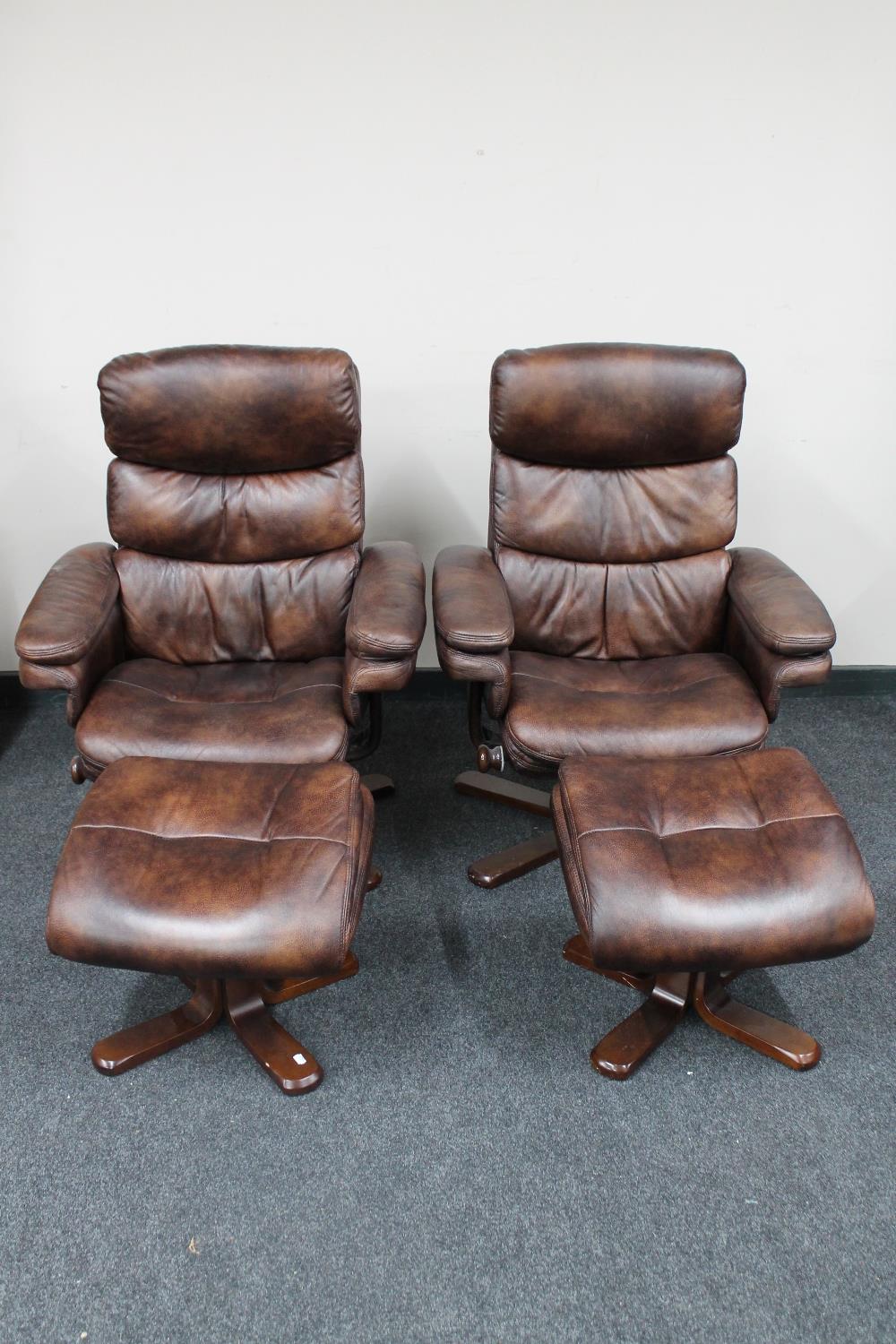 A pair of contemporary swivel adjustable relaxer chairs with stools