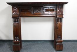 A carved Indonesian hardwood fire surround