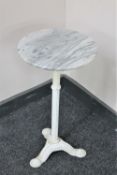 A circular marble topped wine table on a painted cast iron three way base
