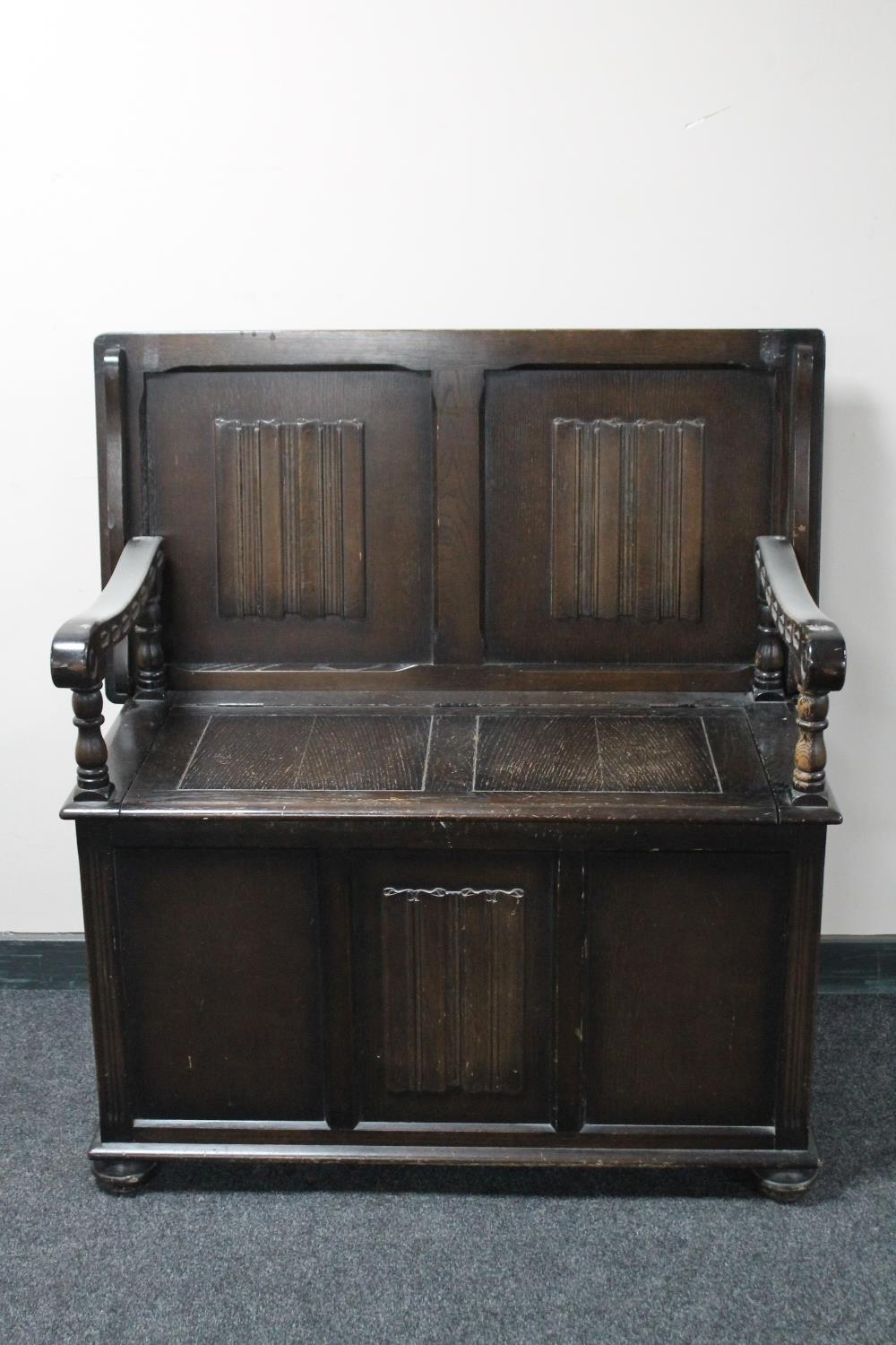 An oak linen fold monk's bench