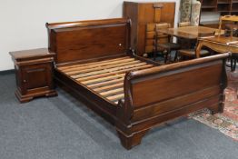 A 4' 6" mahogany sleigh bed with bedside cabinet