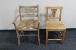 An antique pine rush seated armchair together with an antique pine dining chair