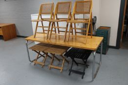 A folding pine top trestle table together with a set of three folding kitchen chairs and three