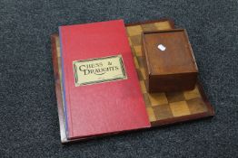 A wooden chessboard together with a boxwood chess set and a further folding chess and draughts