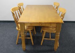A pine farmhouse style kitchen table fitted with two drawers together with a set of four chairs