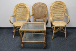 Three bamboo and wicker armchairs together with a bamboo and wicker glass two-tier tea trolley