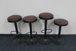 A set of four contemporary circular metal gas lift bar stools