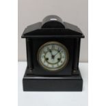 A Victorian black slate mantel clock with brass and enamelled dial