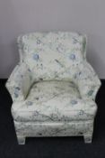 A 20th century armchair upholstered in a cream silk floral fabric