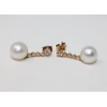 A pair of 14ct yellow gold white pearl and diamond earrings, featuring two white pearls,