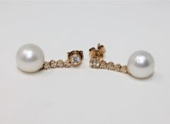 A pair of 14ct yellow gold white pearl and diamond earrings, featuring two white pearls,