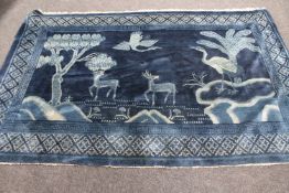 A fringed Chinese rug on blue ground depicting fauna,