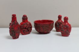 Four Chinese red lacquered scent bottles with stoppers and a bowl