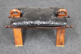 An Eastern brass inlaid saddle stool with leather cushion
