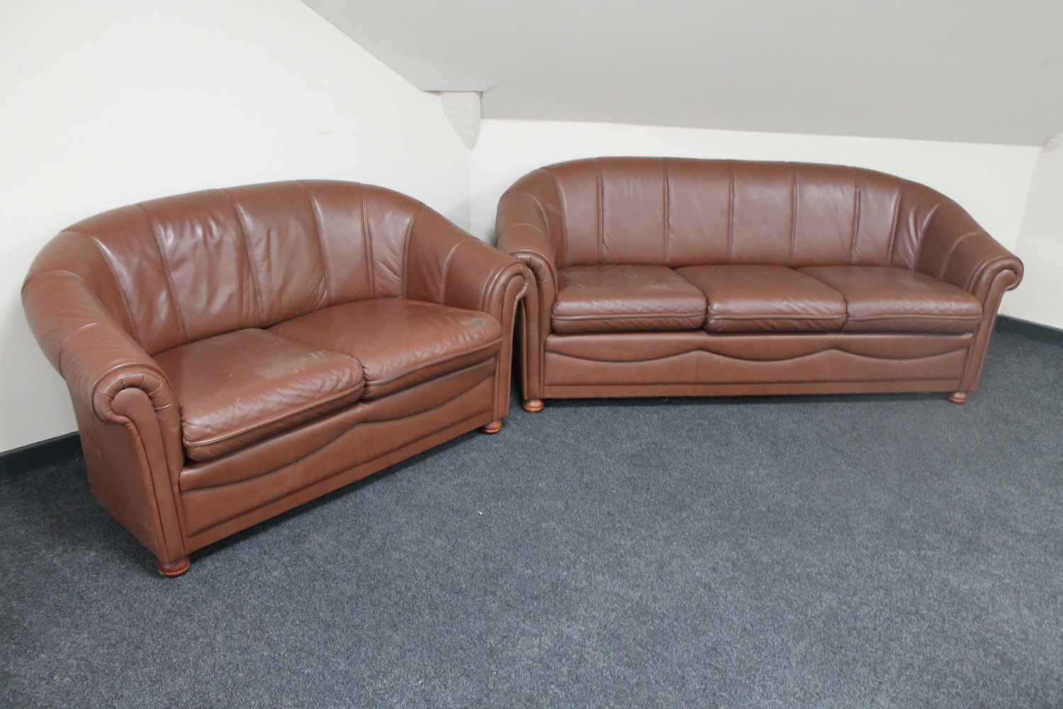 A three seater brow leather settee with matching two seater settee