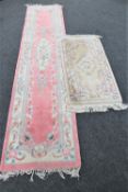 A fringed Chinese runner on pink ground and a fringed Chinese rug on beige ground