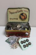 A vintage Squirrell Confections tin containing costume jewellery and buttons