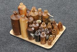 A tray containing approximately twenty-seven antique brown stoneware bottles and jars,