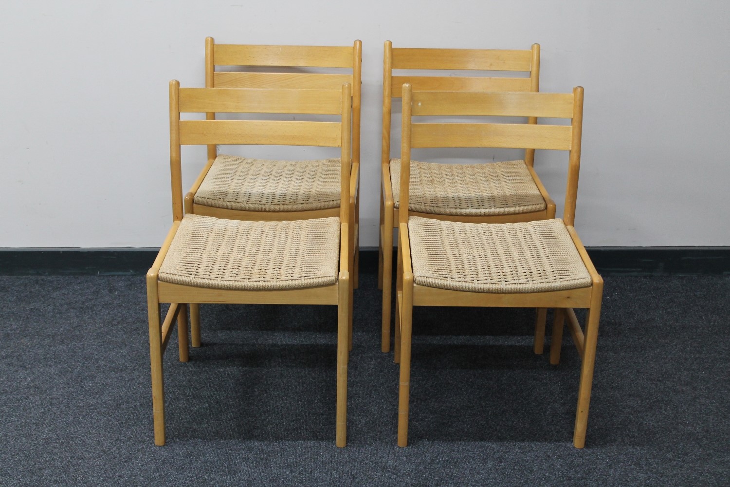 A set of four beech framed rush seated dining chairs