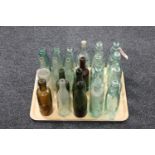 A tray of twenty assorted antique glass bottles and jars, many bearing advertising,