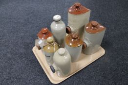 A tray containing seven antique glazed pottery foot warmers