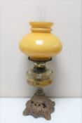 An antique Duplex oil lamp on cast iron base with clear glass reservoir,