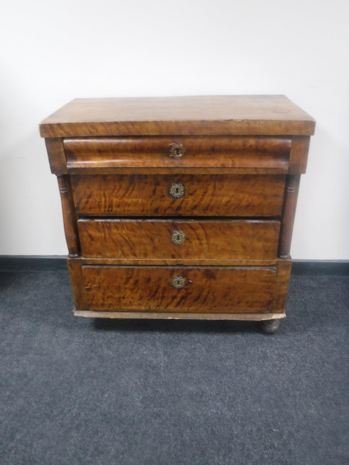 A continental mahogany four drawer chest with pillar supports