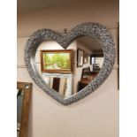 A silvered heart shaped mirror,