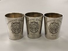 A set of three silver tumbler cups/tots marked Centenaire Genevois 1914