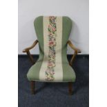 A mid 20th century teak framed armchair upholstered in a tapestry fabric