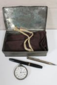 A metal tin containing cloth cutlery bag, silver mechanical pencil, fountain pen,