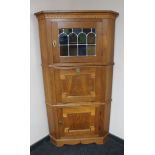 A continental oak triple door corner cabinet
