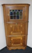 A continental oak triple door corner cabinet