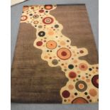 A hand-knotted rug on brown and sand ground,