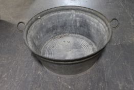 An circular galvanised twin handled wash tub