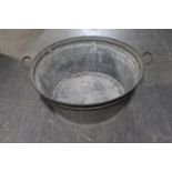 An circular galvanised twin handled wash tub