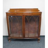 An early 20th century mahogany double door display cabinet on claw and ball feet